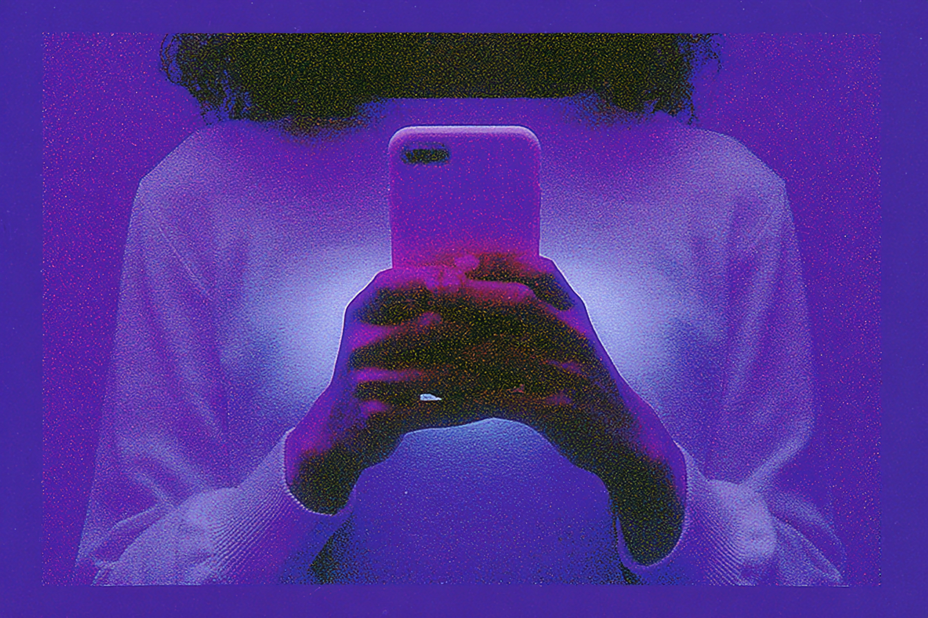 Hands holding a glowing phone in low light